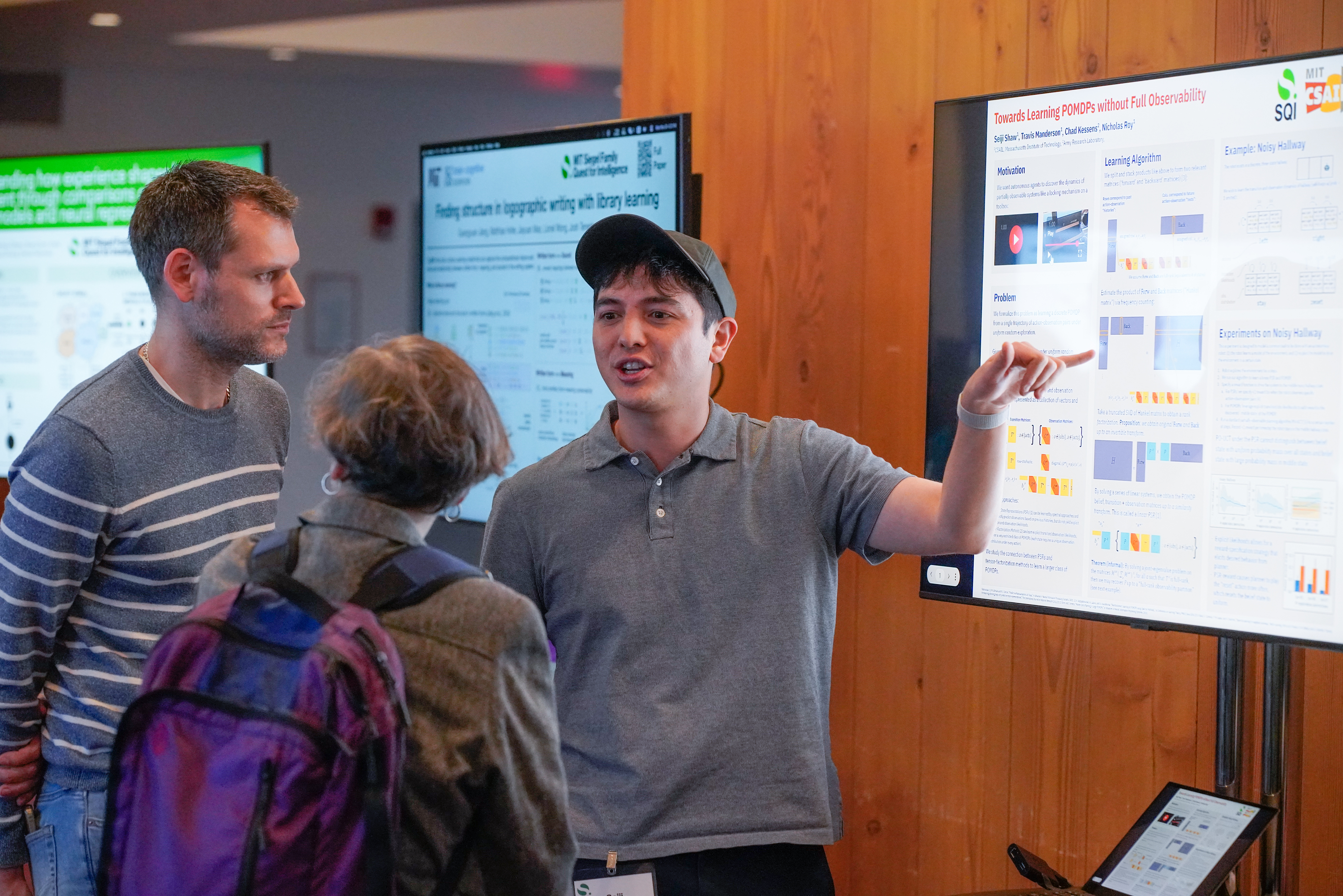a student at a poster talking with two other people