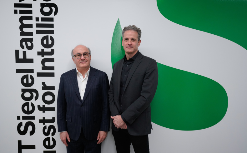 David Siegel with Jim DiCarlo in front of an image of the SQI logo 