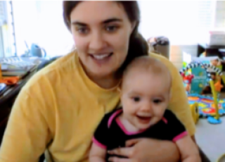 woman holding baby, both looking at camera