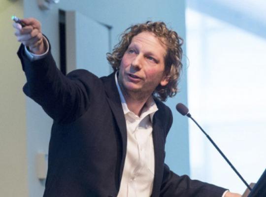 Josh Tenenbaum speaking at a lectern
